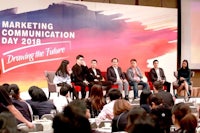 a group of people sitting on a stage at a marketing communication day