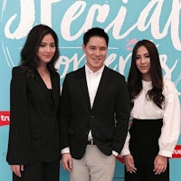 three people standing in front of a sign that says special lovers