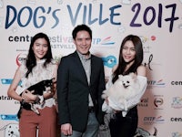 three people posing for a photo at the dog's village festival