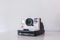 a white polaroid camera sitting on a table