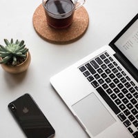 a laptop with a cup of coffee next to it