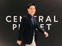 a man walking in front of a sign that says central park
