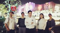 a group of people standing in front of a building at night
