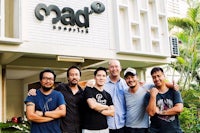 a group of men posing in front of a bam restaurant
