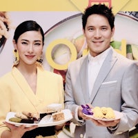 a man and woman posing with plates of food