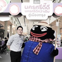 a man standing next to a mascot at an event